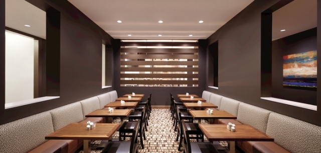 The beautiful dining area in the Embassy Suites Medical Center, Oklahoma City, peeks through the linear slats to the chef's line where exquisite food is created with culinary mastery.  This communal area creates comfort for diners while keeping it casual.